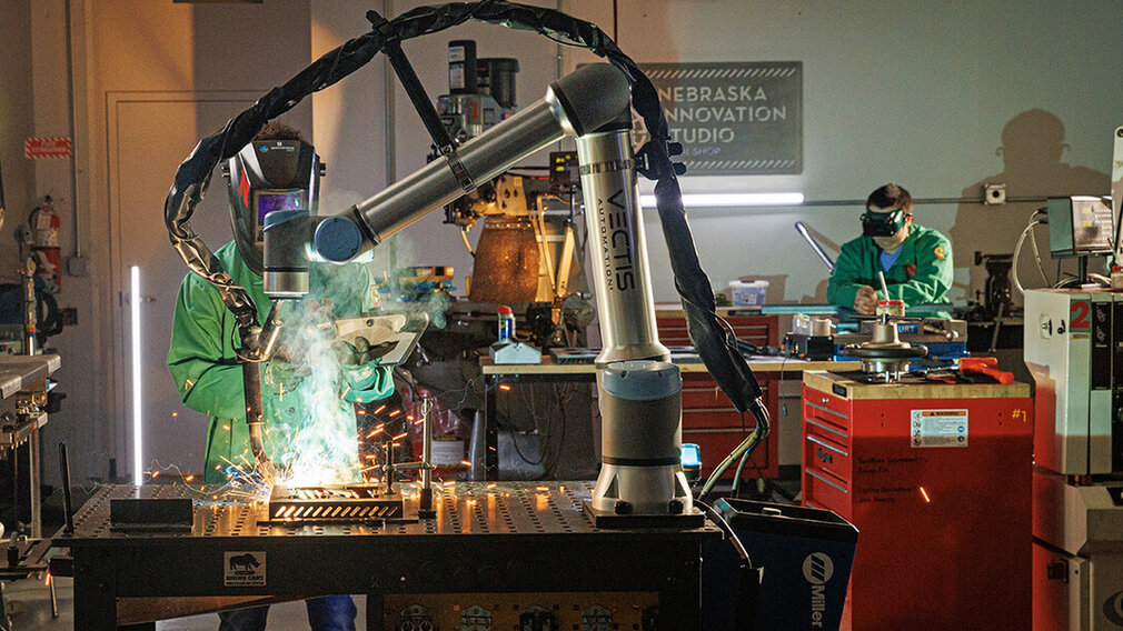A Nebraska Innovation Studio member guides a welding robot in the metal shop.  A Nebraska Innovation Studio member guides a welding robot in the metal shop.